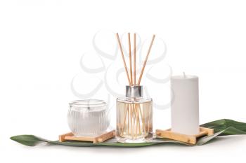 Reed diffuser and candles on white background�