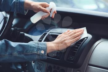 Woman disinfecting salon of car�