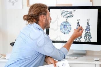 Male jewelry designer working in office�