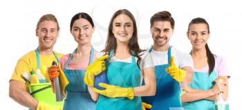 Team of janitors with cleaning supplies on white background�