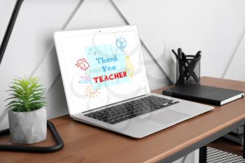 Modern laptop with text THANK YOU, TEACHER on screen, notebook and stationery on table. Teacher's Day celebration�