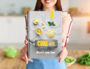 Young woman with cook book in kitchen, closeup�