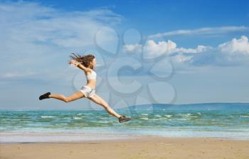 Royalty Free Photo of a Girl Leaping on the Beach