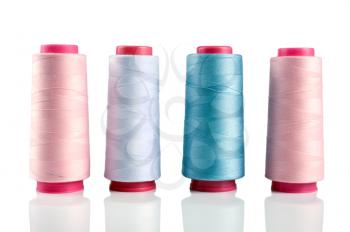 Some plastic spools with multicoloured threads isolated on white