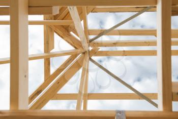 New residential construction home wooden framing against a cloudy sky