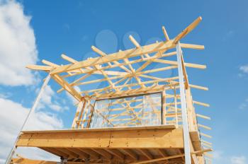 
New residential construction home wooden framing against a blue sky