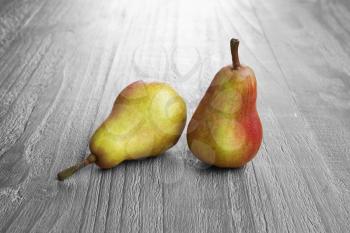 two colorful pears closeup on vintage wooden background