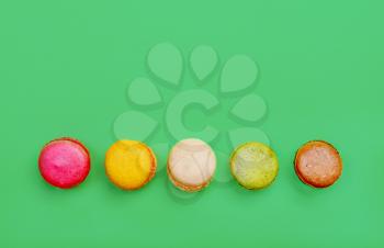 Colorful and tasty  French Macarons on green background.Top view.