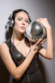 Portrait of attractive brunette with a mirror ball in her hands