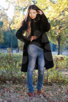 Portrait of a lovely young brunette in autumn park