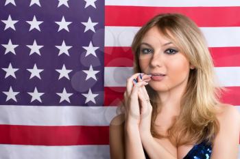 Beautiful young blonde on a background of the American flag
