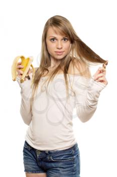 Young pretty woman holding banana and playing with her hair. Isolated on white