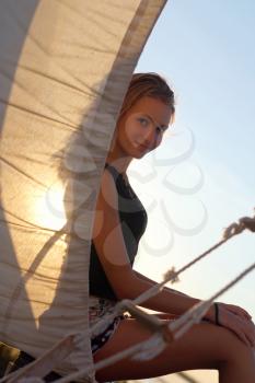 Charming teen girl sitting at stern of the ship
