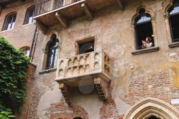 VERONA, ITALY - MAY 7, 2014: Girl photographs on their smartphone from a window in the museum courtyard Juliet. Verona, Italy