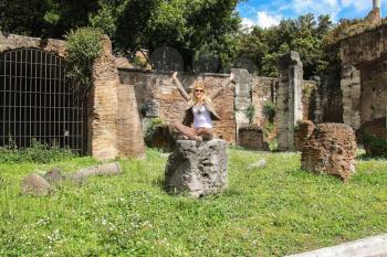 Attractive girl near the picturesque ruins of Rome, Italy