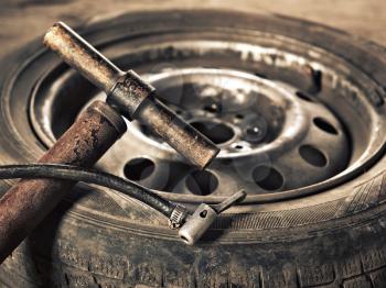 old hand-pump and car wheel close-up