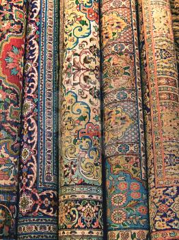 Indian carpets are rolled into rolls as background