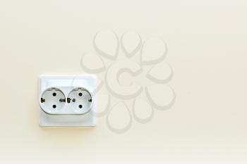 white double electrical outlet on a beige wall