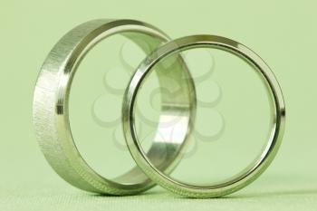 two wedding rings on a green background
