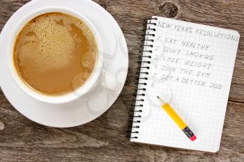 New year resolutions with  coffee cup on the wooden background
