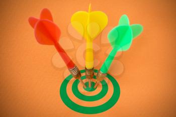 Three darts hitting green target on orange background