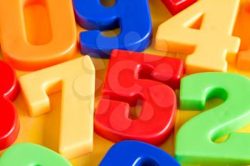 Colorful plastic numbers on a painted wooden background