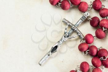 Catholic rosary on old paper background with copy-space