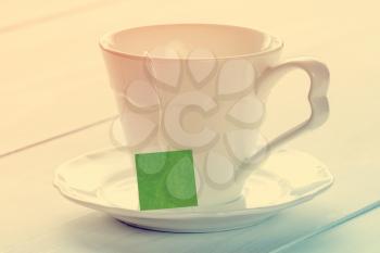 Soft pastel still life with teacup on wooden background