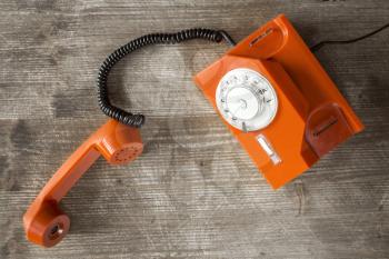 Old orange retro phone with rotary dial. Top view.
