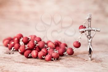 Close-up view of rosary on wooden texture background
