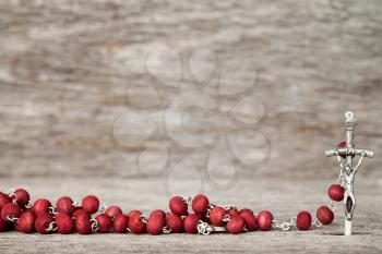 Close-up view of catholic rosary on wooden texture background