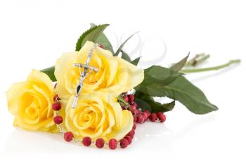 Silver crucifix and yellow roses,isolated on white background