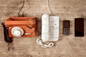 Old telephones and modern mobile phone show evolution in telecommunications