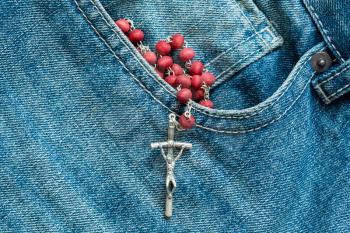 Catholic rosary in the pocket of the blue jeans