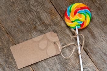 Lollipop with a blank tag on a wooden background