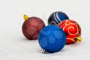 Four Christmas baubles on the snow. Christmas and New Yer Holidays