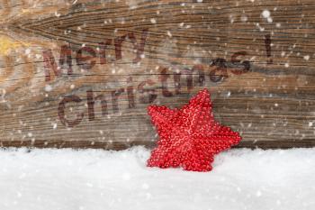 Merry Christmas message on wooden background with red Christmas star