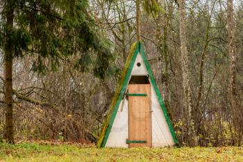 Outdoor toilet in the forest during autumn season