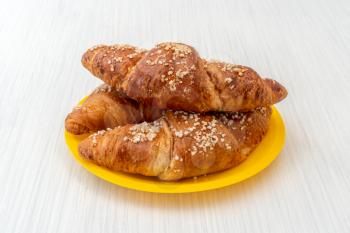 Yellow plate with freshly baked croissants 