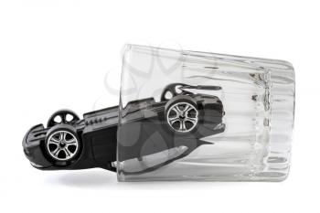 Toy car in a vodka glass isolated on white background. Drunk driving concept.