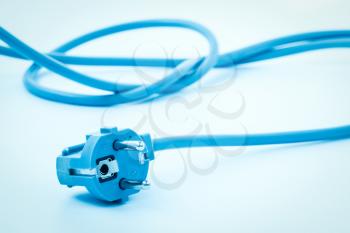 Plug of power supply 230V with a long cord. Blue toned image.