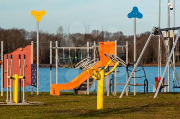Fitness equipment  and playground for children in the park near the water 