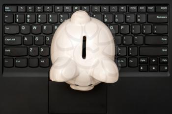 Piggy bank on the black computer keyboard, top view.Make money online or internet business.