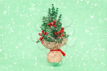 Christmas holiday creative greeting card idea with plastic spruce and snowfall. Winter holiday decoration.