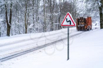 Heavy transport on the curvy snowy country road