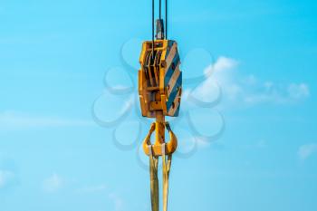  Closeup view of crane hook against blue sky 