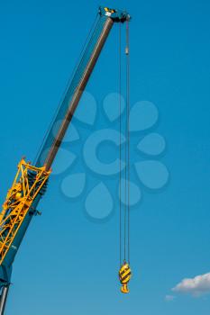 Boom of mobile crane with clear blue sky background. Telescopic boom of crane