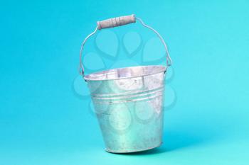 Empty metal bucket  on the blue background
