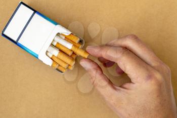 Close-up view of smoker hand take a cigarette from the pack