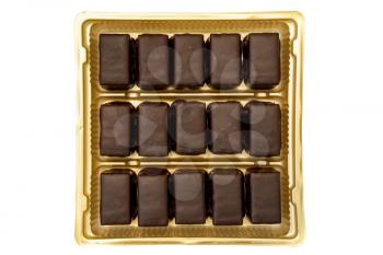 Dark chocolate pralines in a golden square box isolated on white background